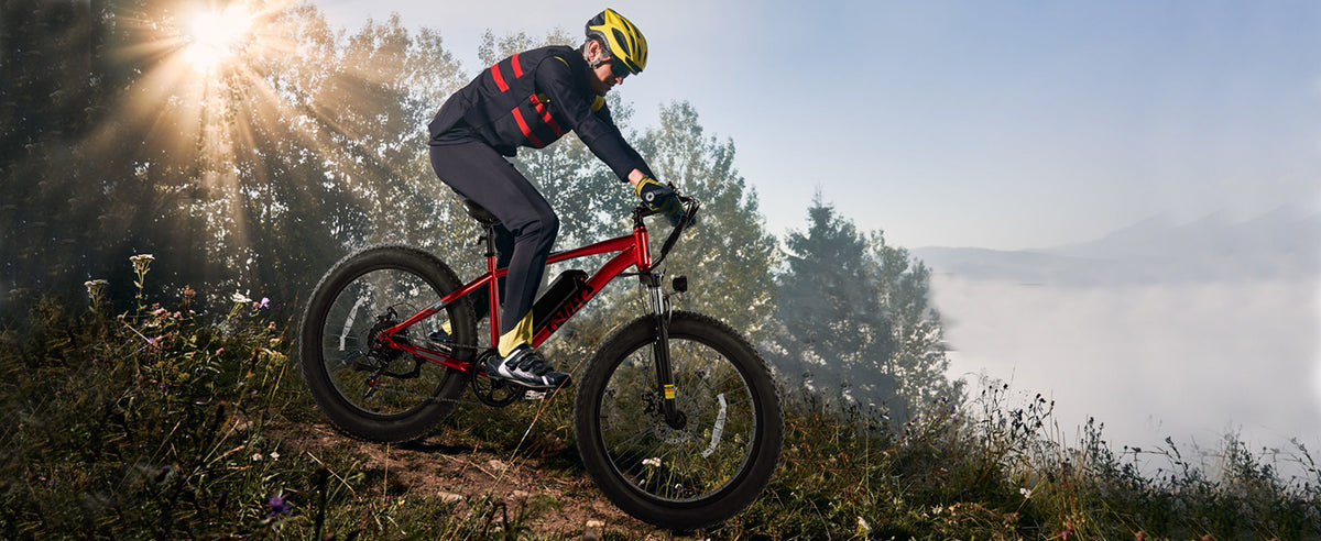 Rider using a red Qlife fat tire electric bike on a mountain trail